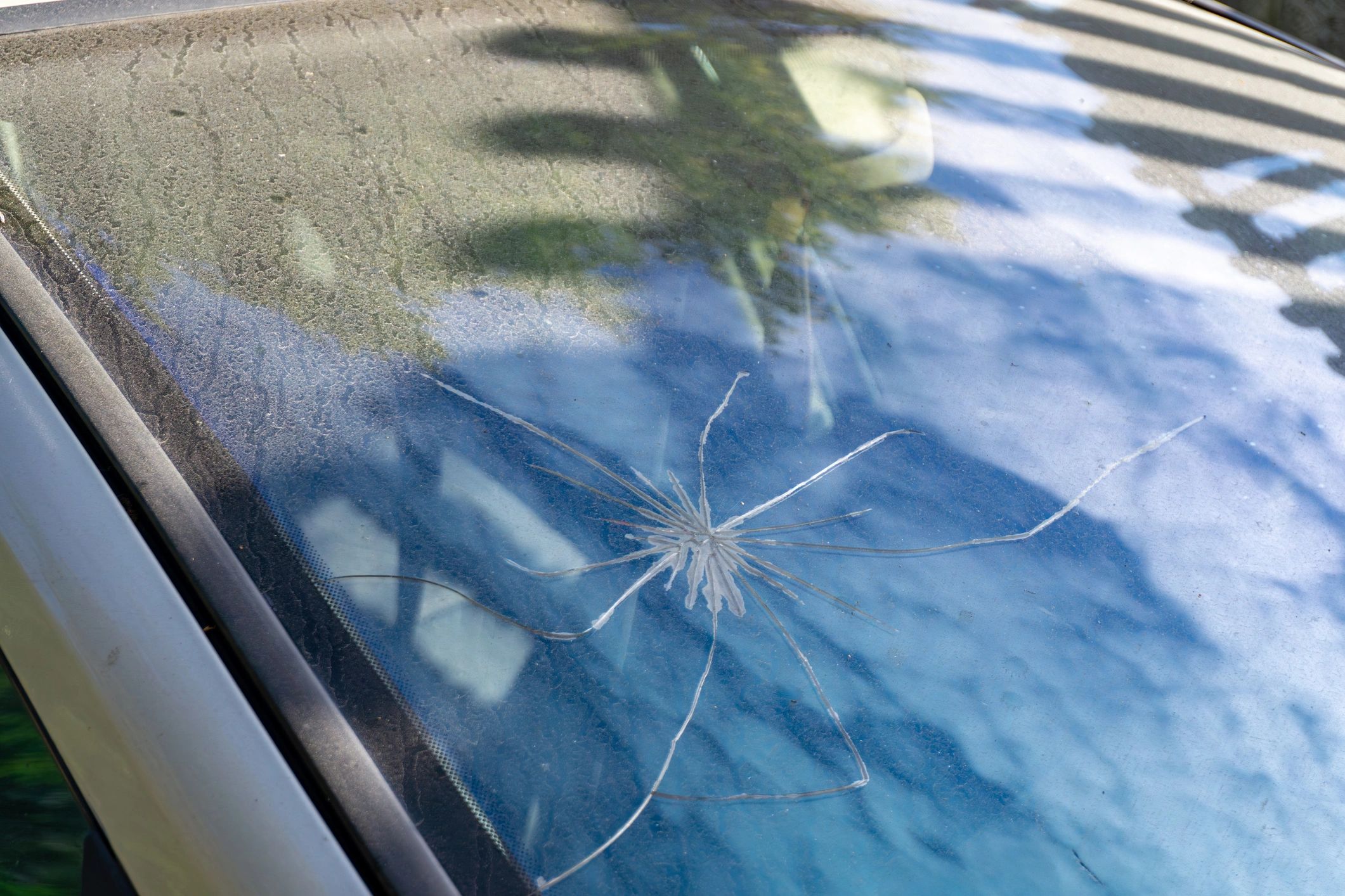 Cracked car windshield, a broken vehicle windshield being repaired by Juste's Glass