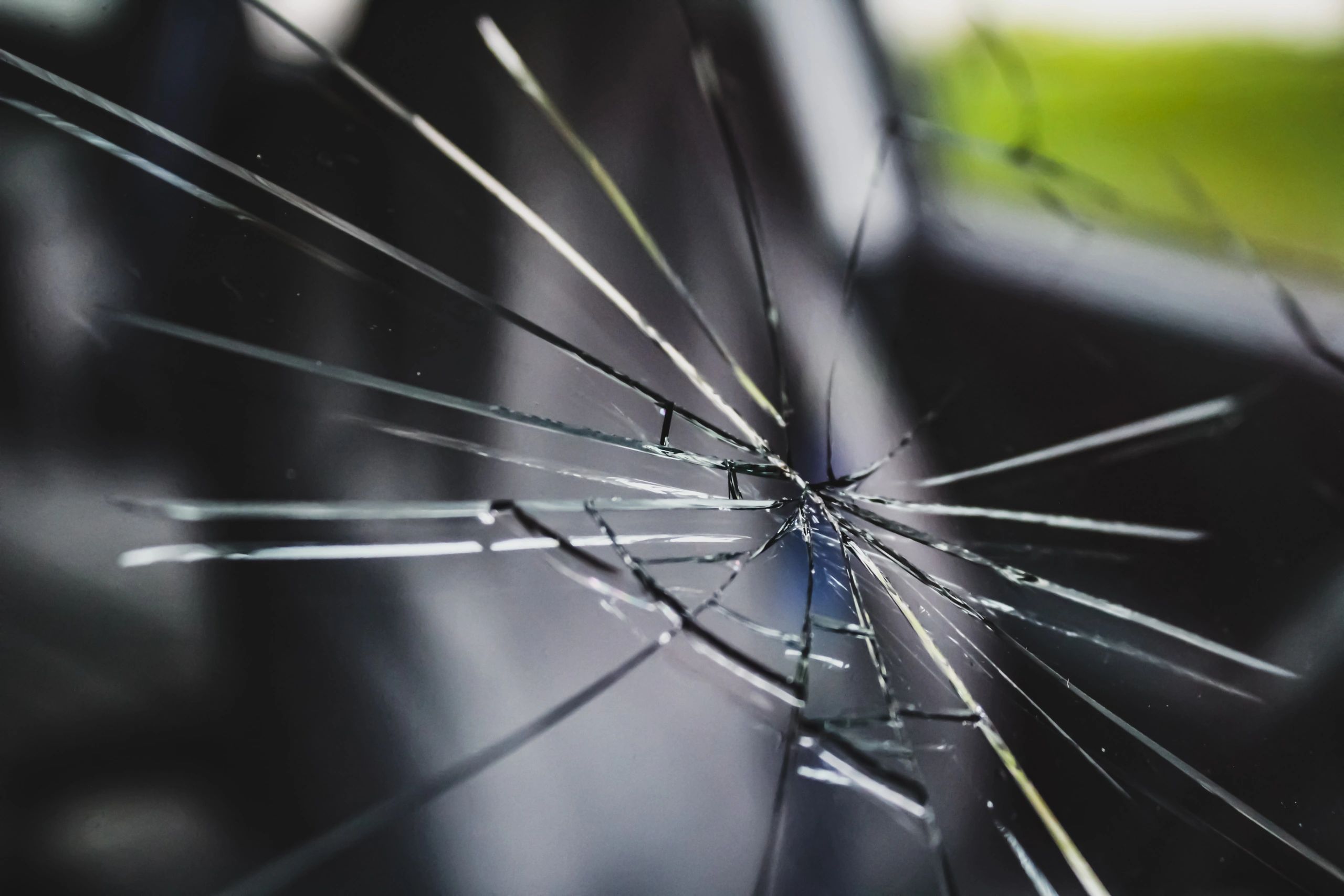A chip, crack, or shattered piece of glass on a car windshield.