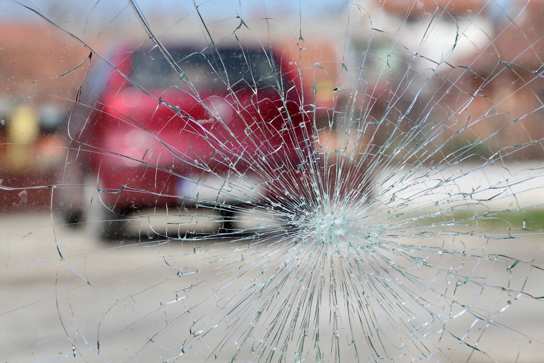 A person driving with a shattered windshield.